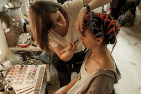 Maskenbildnerin Aisha King macht ein Make-up mit Frisur für die Oper 